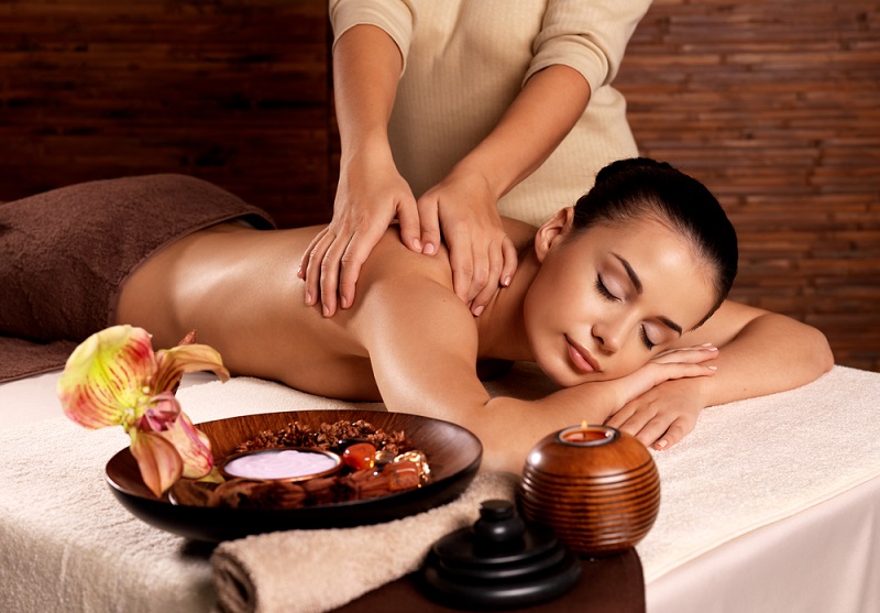 Masseur doing massage on woman body in the spa salon. Beauty treatment concept.